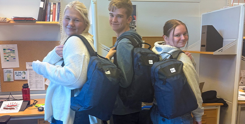 Tre personer som visar upp varsin ryggsäck.