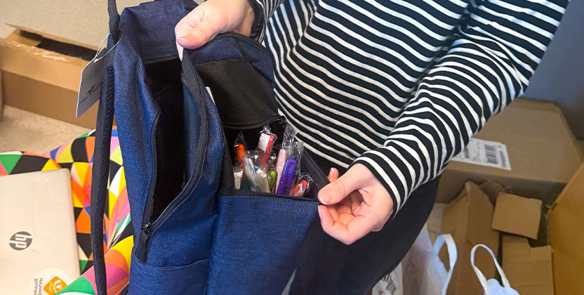 Person som håller i ryggsäck med tandborstar i.