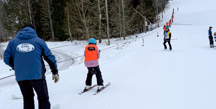 Barn som åker knapplift i skidskola.