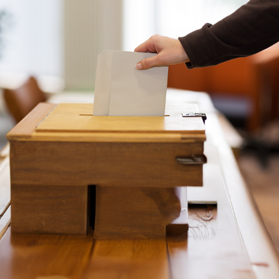Person som lägger valsedel i valurna.